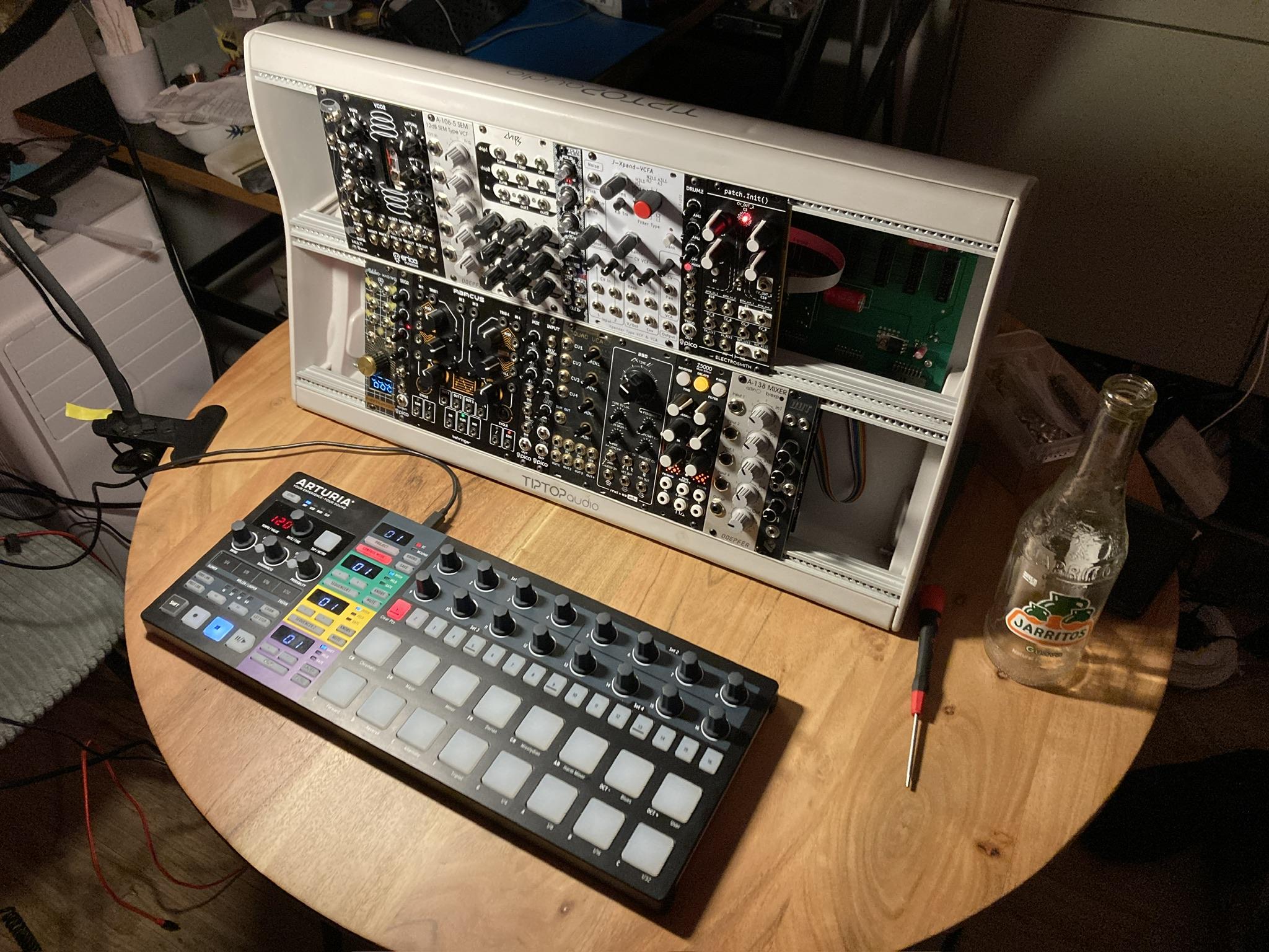 Modular synthesizer with arturia sequencer on table.
